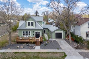 A two-story house with a front deck, a garage, and a small shed. - Spacious Downtown Location | 4BA, 2 Kitchens + Game Room (Cheyenne)