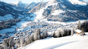 Paesaggio montuoso innevato con un paese incastonato nella valle.