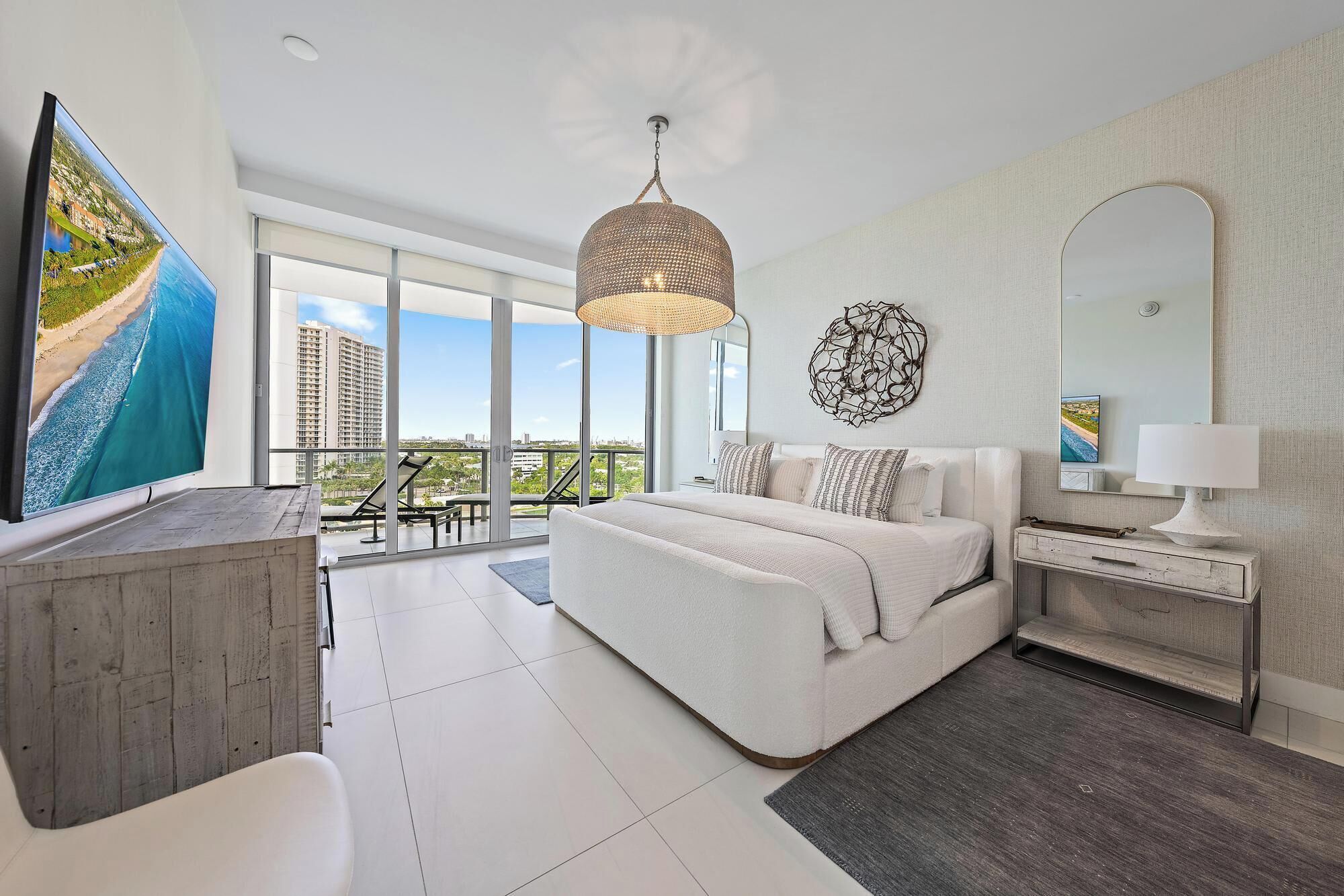 Une chambre moderne avec un grand lit, un bureau, une télévision et un balcon offrant une vue agréable.