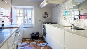 Eine moderne Küche mit weißen Schränken, einem Gasherd, einer Spüle und einem Fenster mit Blick.