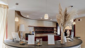 A reception desk with a computer, a menu stand, and decorative items including a vase with pampas grass. - Hotiday Room Collection - Mattinata Faraglioni (Mattinata)