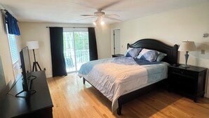 A bedroom with a bed, a desk, a ceiling fan, and a window with curtains. - Summer Beach Rental w/ Beach Pass - 3 bed/3 bath (Charlestown)