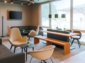 Un espace de détente moderne comprenant un canapé, des fauteuils, une table basse et un banc en bois.