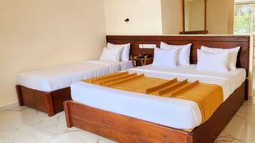 Una cama doble con cabecera de madera y una cama individual a la izquierda.