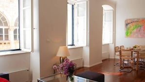 A spacious living area with a glass coffee table, a sofa, and a dining table with chairs. - La Dolce Vita-Old Town (Dubrovnik)