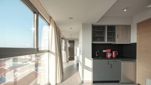 A modern kitchen with a view to the outside, a small refrigerator, and a coffee maker. - Sky-High Central Penthouse w. Stunning Views - 01

 (Chania, Crete)