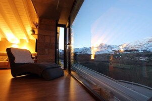 Un interior moderno con un amplio ventanal que da a un paisaje nevado y una vía de tren.