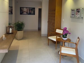 Welcome to our reception area, where guests can check in and relax in a comfortable seating area with a wooden bench and a potted plant.