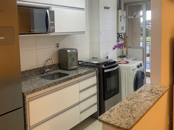 Enjoy cooking in this well-equipped kitchen with a refrigerator, microwave, compact stove, sink, and dishwasher.