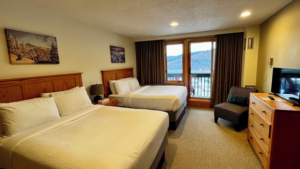 A hotel room with two beds, a television, a dresser, and a balcony with a view. - SkiBoltonValleyVTPresWkFeb12-19Slopeside1bdrm2bthSteSlps8 (Richmond)