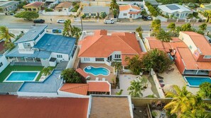 Houses with unique architectural styles and lush greenery surround a well-maintained neighborhood.