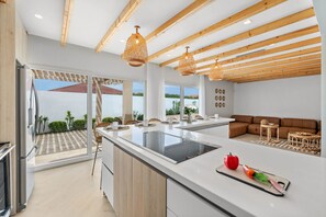 Enjoy cooking in the spacious kitchen with a large island and stovetop, offering a view of the surrounding landscape.