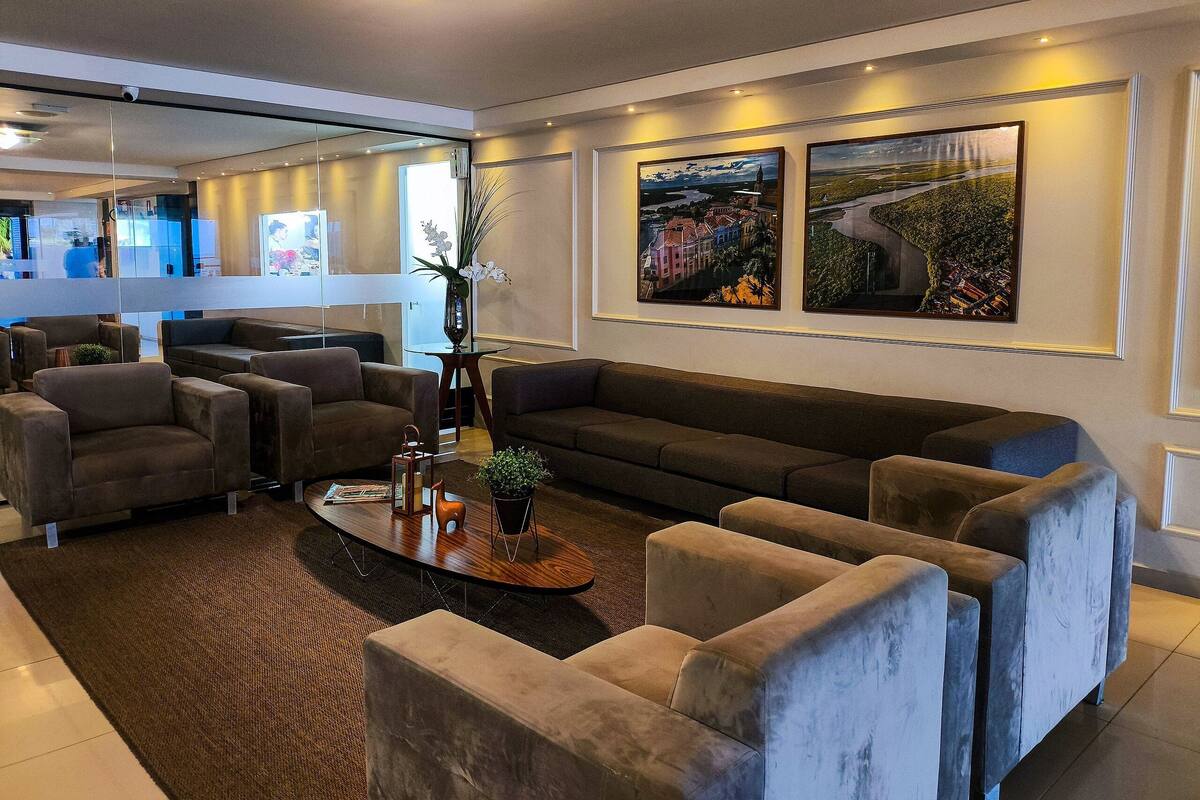 A modern hotel lobby with sofas, a coffee table, and artwork on the walls.