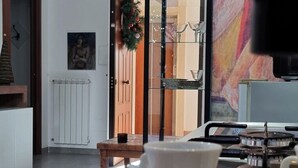 Una cocina moderna con una cafetera, una taza y una bandeja. Se ve una ventana con vistas a un paisaje urbano.