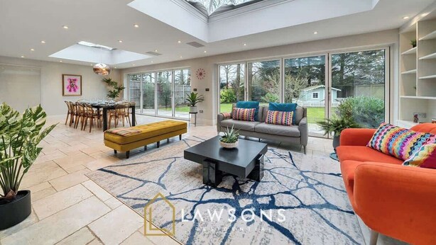 A spacious living room with a skylight, a dining area, and a sofa with colorful cushions. - Legoland Basecamp | Perfect for Families | Sleeps 15 (Windsor)