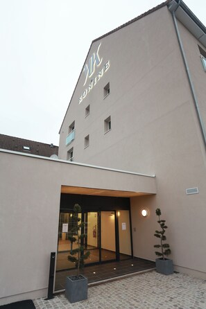 Un edificio con un letrero que dice 'Hotel' y una entrada con portón.
