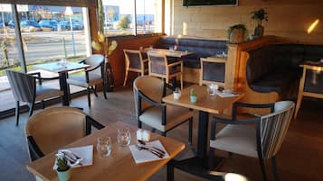Un espace de détente intérieur avec des tables, des chaises et un canapé.