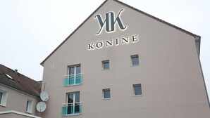 Rakennuksessa on kyltti, jossa lukee ”KONINE”, ja sen katto on kolmion muotoinen.
