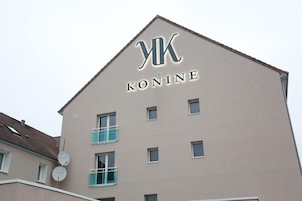 A building with a sign reading 'KONINE' and a triangular roof.