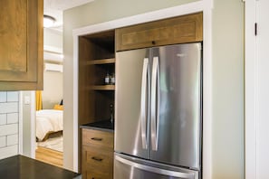 A kitchen with a stainless steel refrigerator, wooden cabinets, and a countertop.