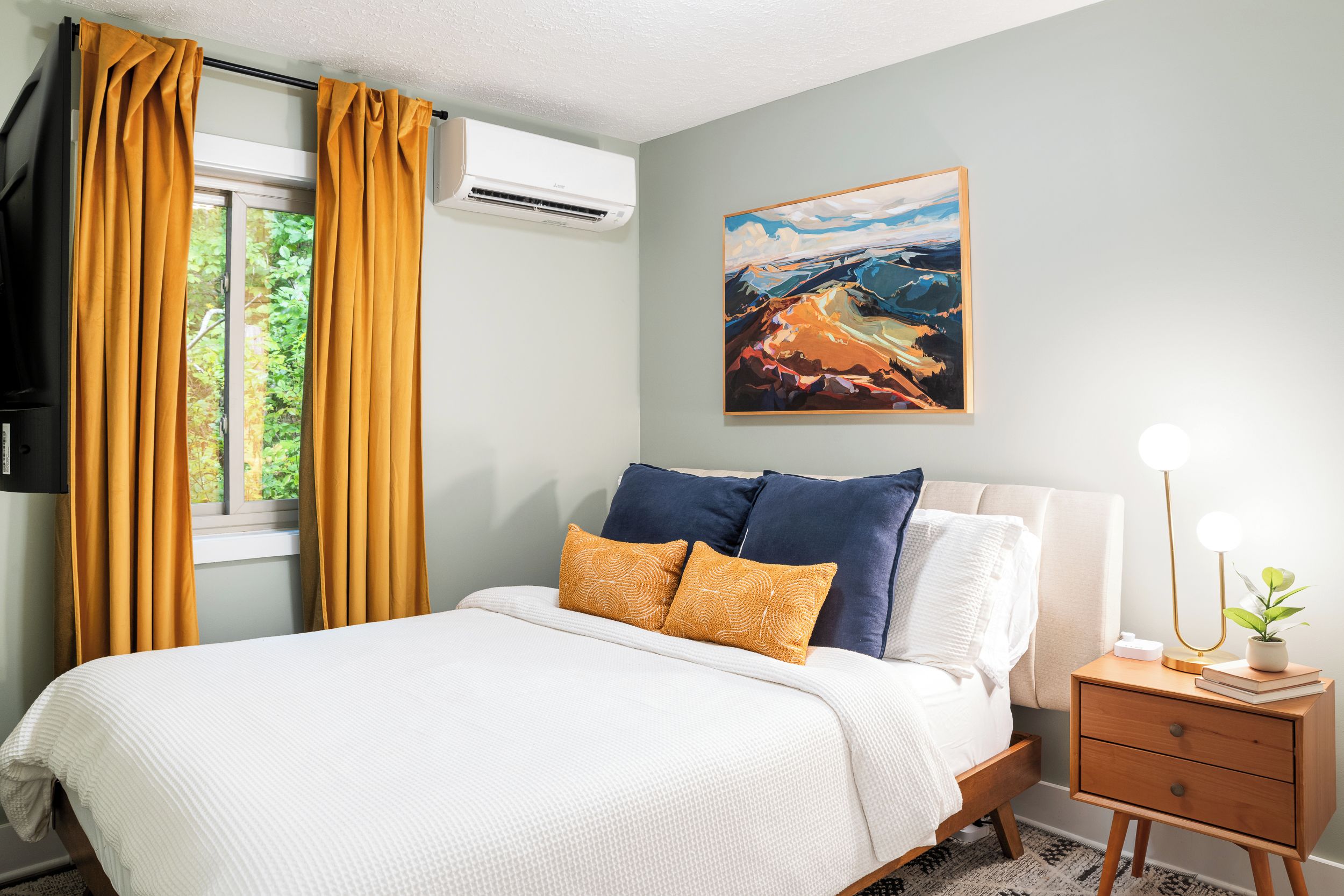 Bright bedroom with mustard and navy accents. 