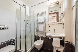 A modern bathroom with a glass shower enclosure, a bidet, a sink, and a mirror. - Together Florence Urban Resort (Bagno a Ripoli)