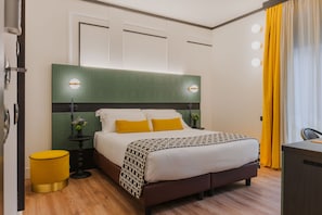 A neatly arranged bedroom with a bed, bedside tables, a green headboard, and a yellow curtain. - Together Florence Urban Resort (Bagno a Ripoli)