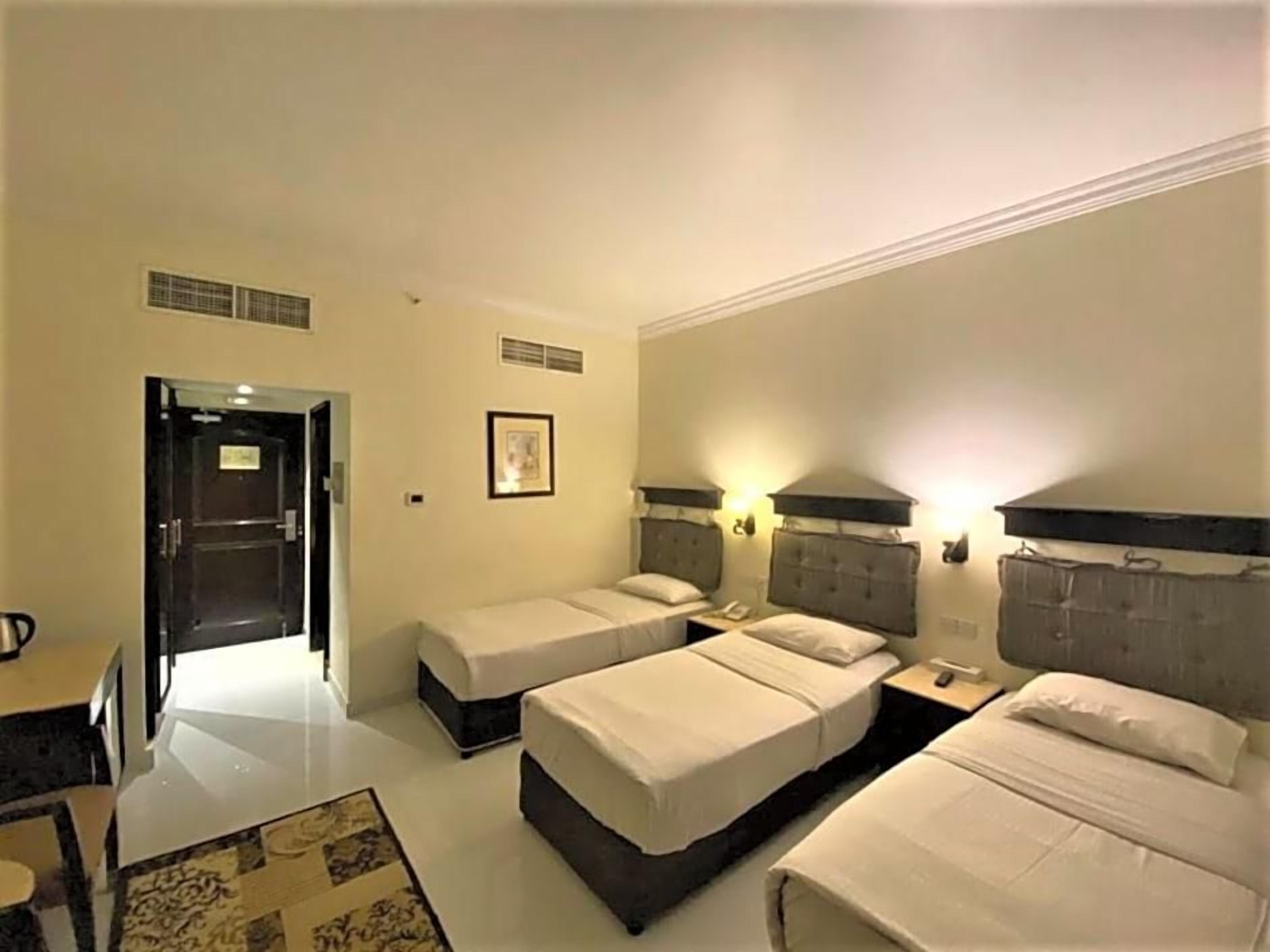 Habitació d'hotel amb dos llits individuals, un escriptori i una cadira.