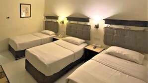 Habitació d'hotel amb dos llits individuals, una tauleta de nit amb un telèfon, i un quadre al mur.