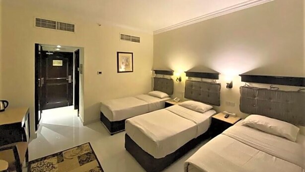 Habitació d'hotel amb dos llits individuals, un escriptori i una cadira.