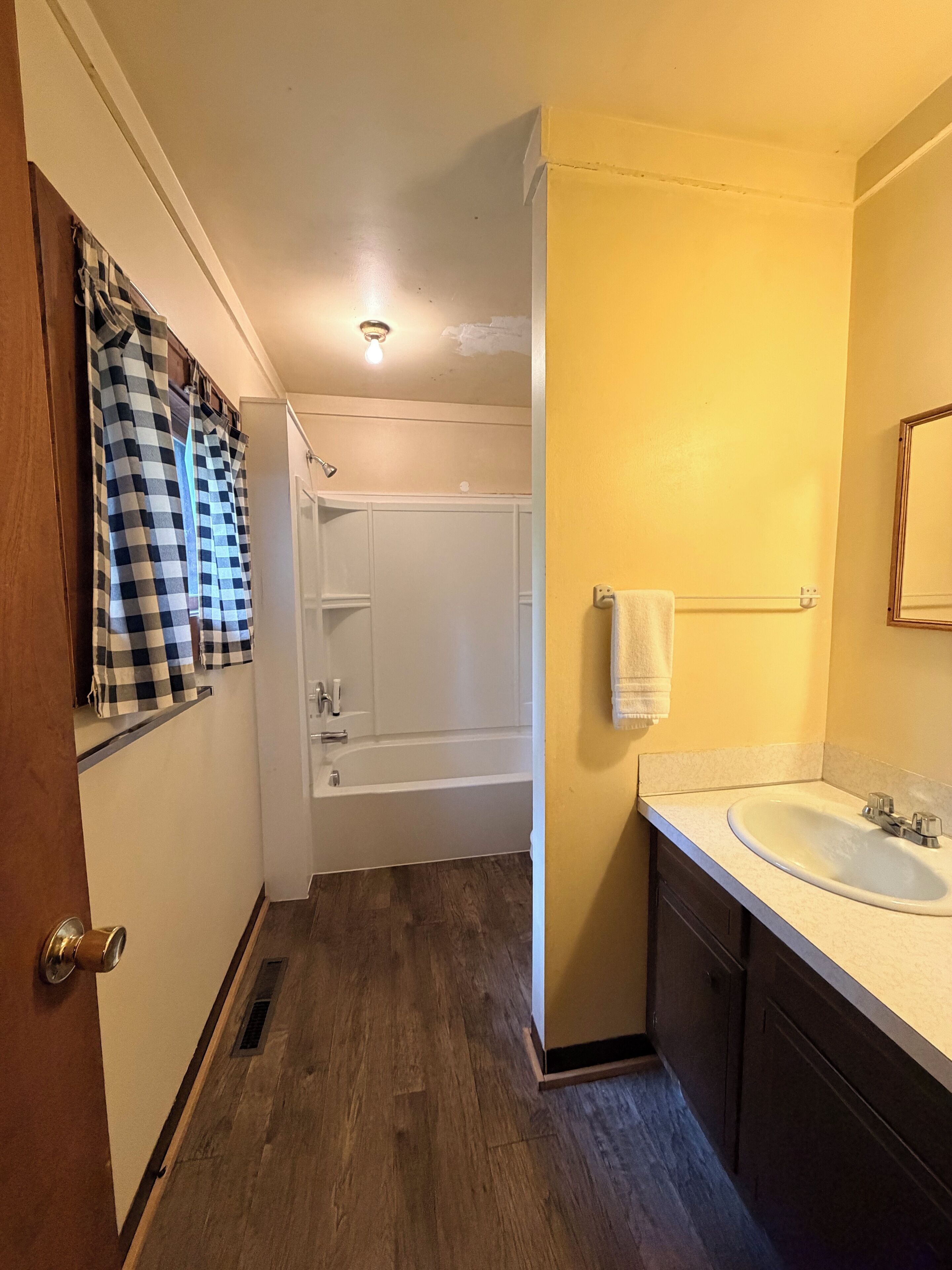 A bathroom with a bathtub, a sink, and a mirror.