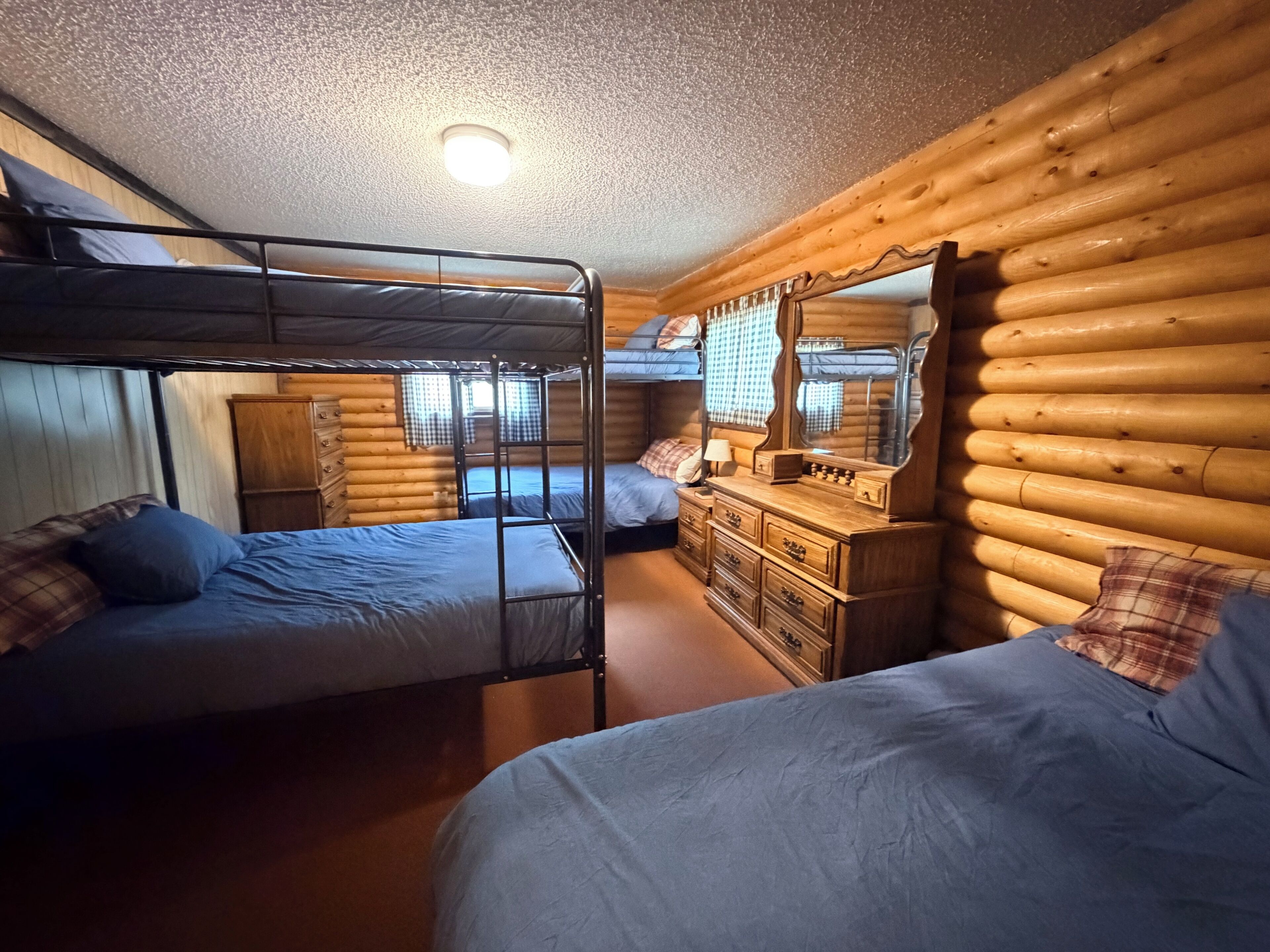 Ein Schlafzimmer mit Etagenbetten, einem Schminktisch und einem Spiegel.