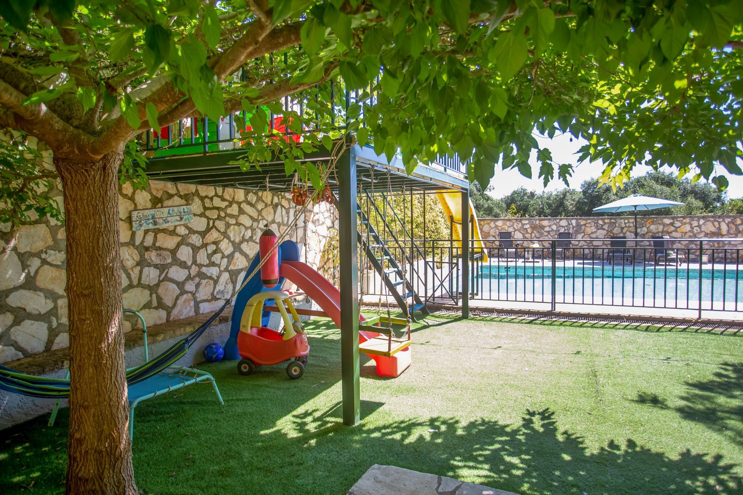 A playground with a slide, swings, and a small playhouse.