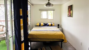 Una camera da letto con un letto, una finestra e un portone che dà su un balcone.