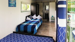 A bedroom with a bed, a ceiling fan, a window, and a door leading to another room. - BlueEcolandia (Jarabacoa)