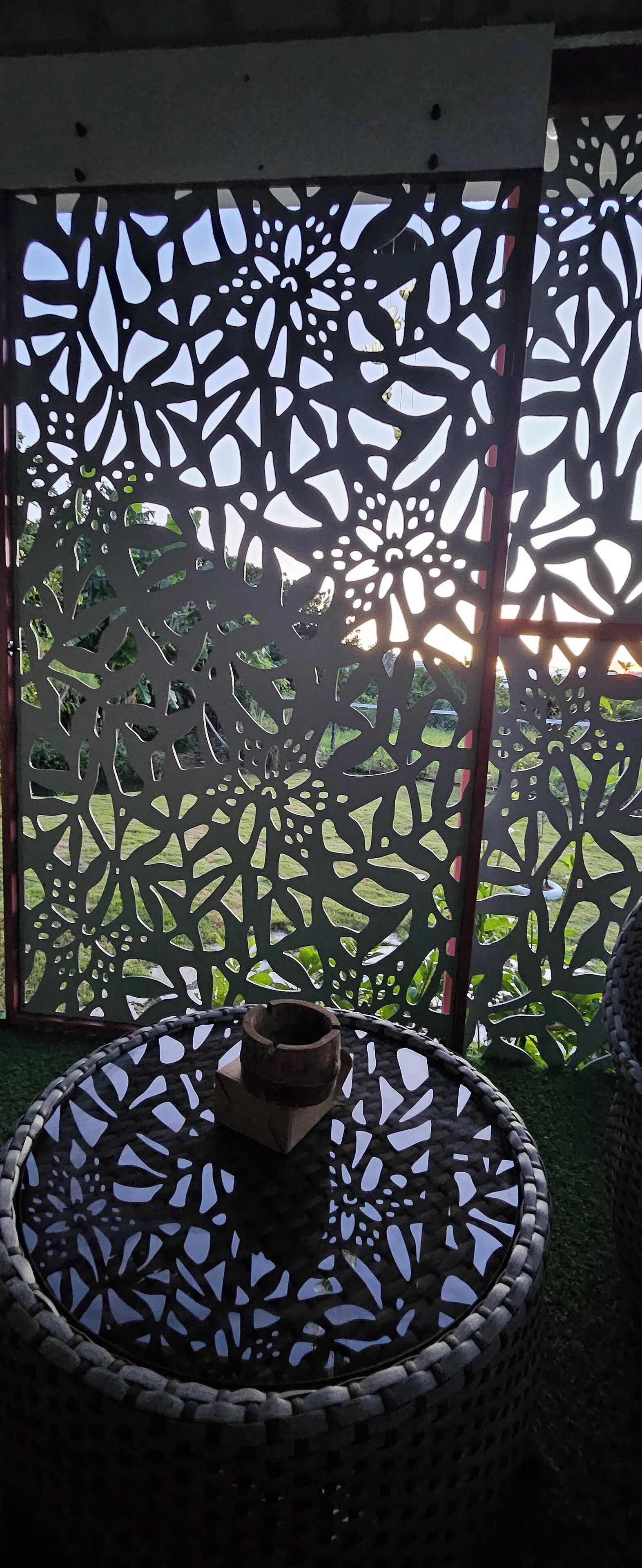 A wicker outdoor seating area with a decorative metal partition.
