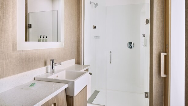 A modern bathroom with a glass-enclosed shower, a double sink, and a mirror above the sink. - SpringHill Suites by Marriott St. Louis Chesterfield (Chesterfield)
