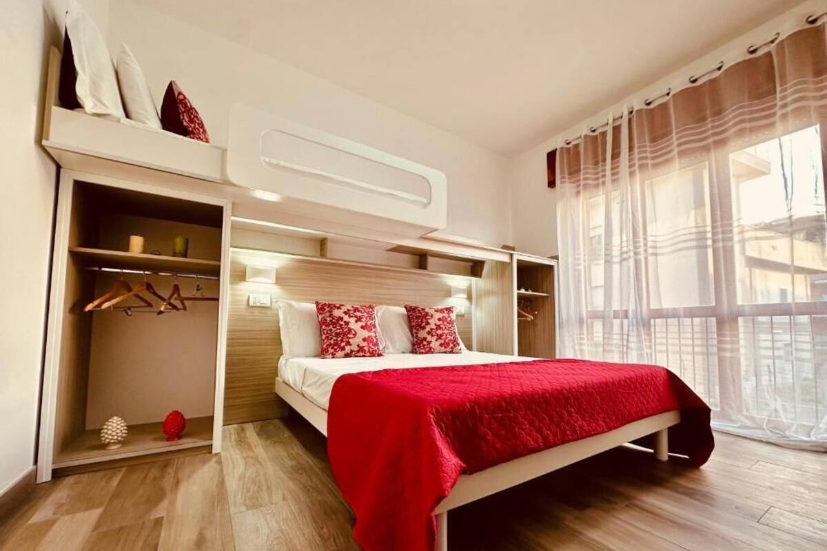Een slaapkamer met een bed, een kledingkast en een raam met gordijnen.