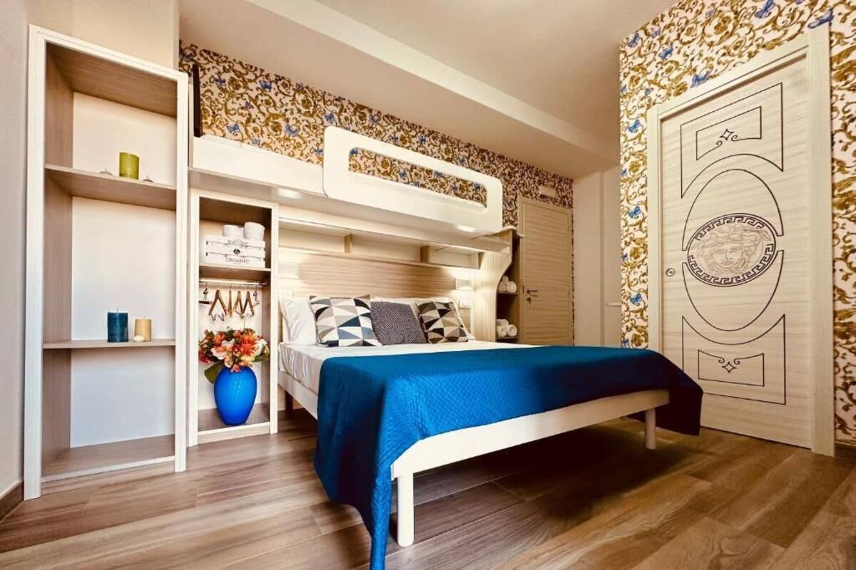 Een slaapkamer met een stapelbed, een garderobe en een kaptafel met spiegel.