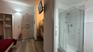 A hotel room with a shower, a bed, a TV mounted on the wall, and a hallway with a door leading to another room. - B&B THE SEA - Family Rooms (Tropea)