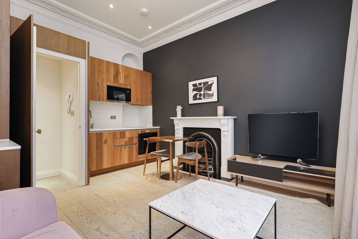 Un salon moderne avec une cheminée, un téléviseur et des meubles en bois.