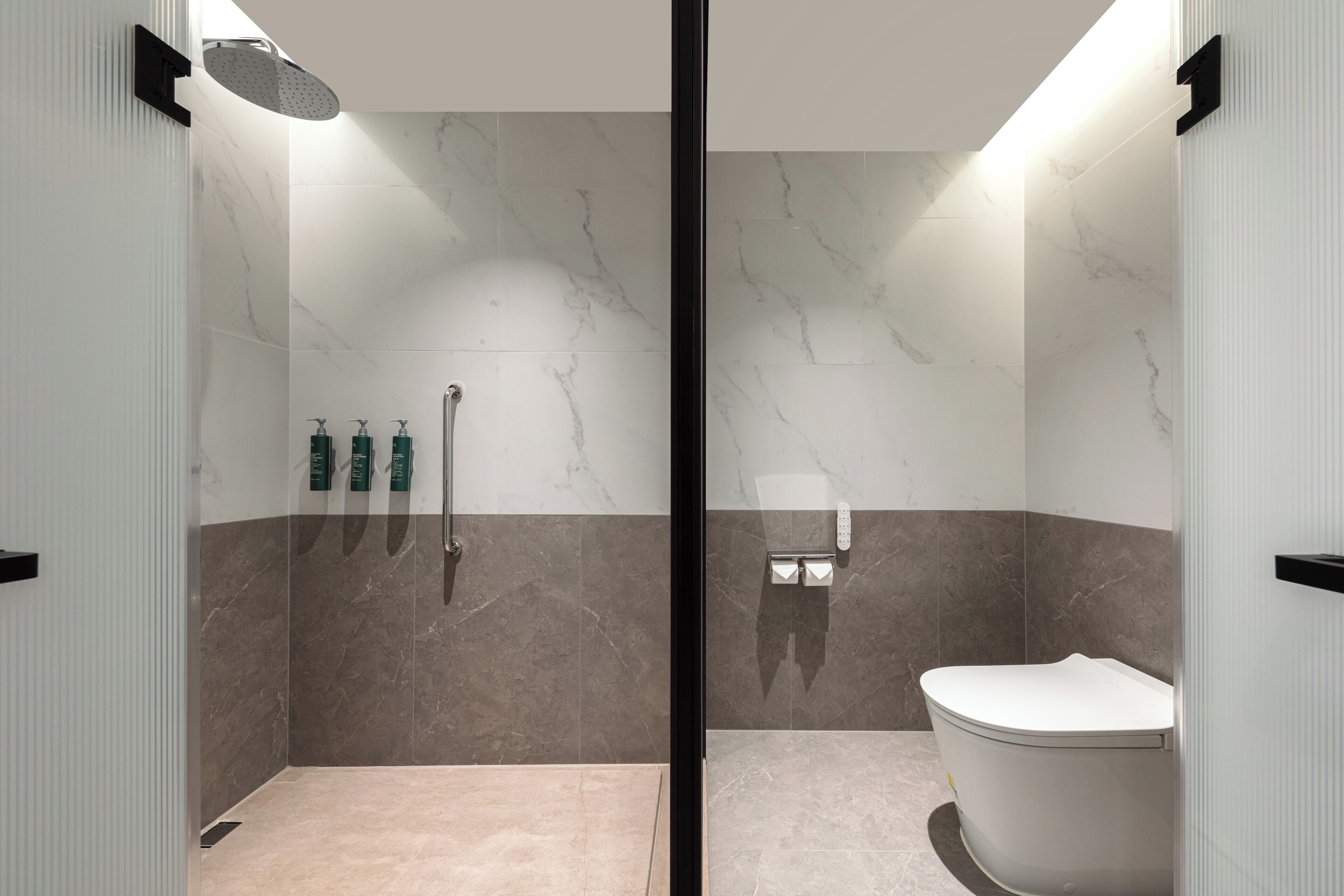 Un baño moderno con ducha, inodoro y secamanos.