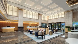 Un hall d’entrée spacieux avec un comptoir d’accueil, un espace salon et de grandes fenêtres.