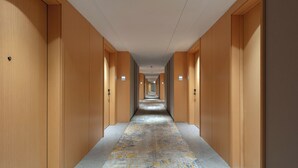 Un long couloir étroit aux murs et aux portes en bois, qui mène à une extrémité éloignée.