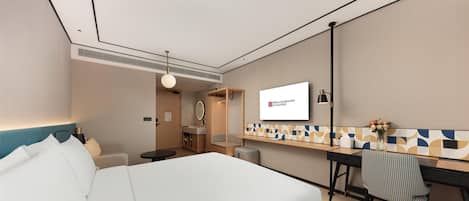 A hotel room with a bed, a desk, a chair, a TV, and a bathroom.
