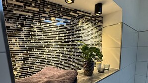 A modern bathroom with a tiled backsplash, a towel on the counter, and a potted plant. - Erfurt Lakes vacation apartment - at the gates of the Thuringian state capital  (Nöda)