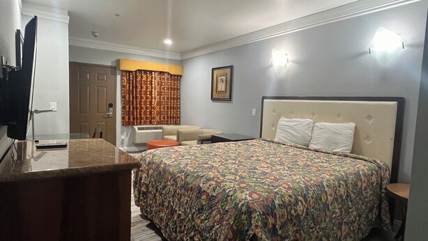 Un dormitorio con cama, mesita de noche y escritorio con silla.