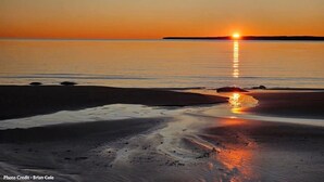 A beach at sunset with calm waters reflecting the sun. - Beaver Island - Cleveland's Big Chill  (Beaver Island)