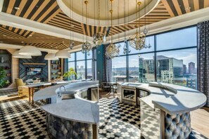 Enjoy cooking in this well-equipped kitchen with a curved island, sink, and oven, offering a city view.