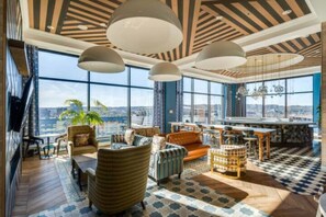 Relax in a serene space with a panoramic city view, featuring a coffee table and comfortable seating.